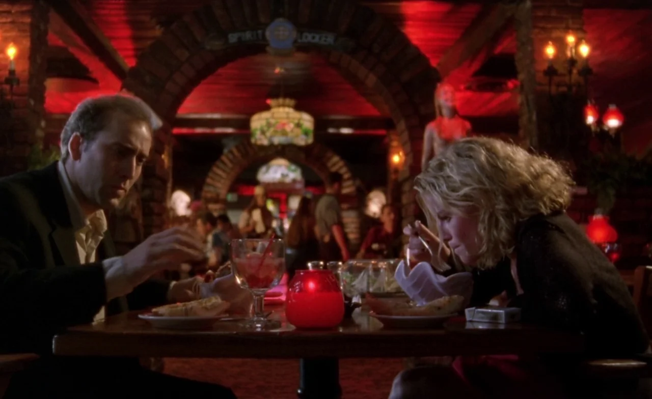 Leaving Las Vegas (1995) movie still: medium — A dimly lit restaurant interior features wood-paneled walls and arched architectural details. A man…