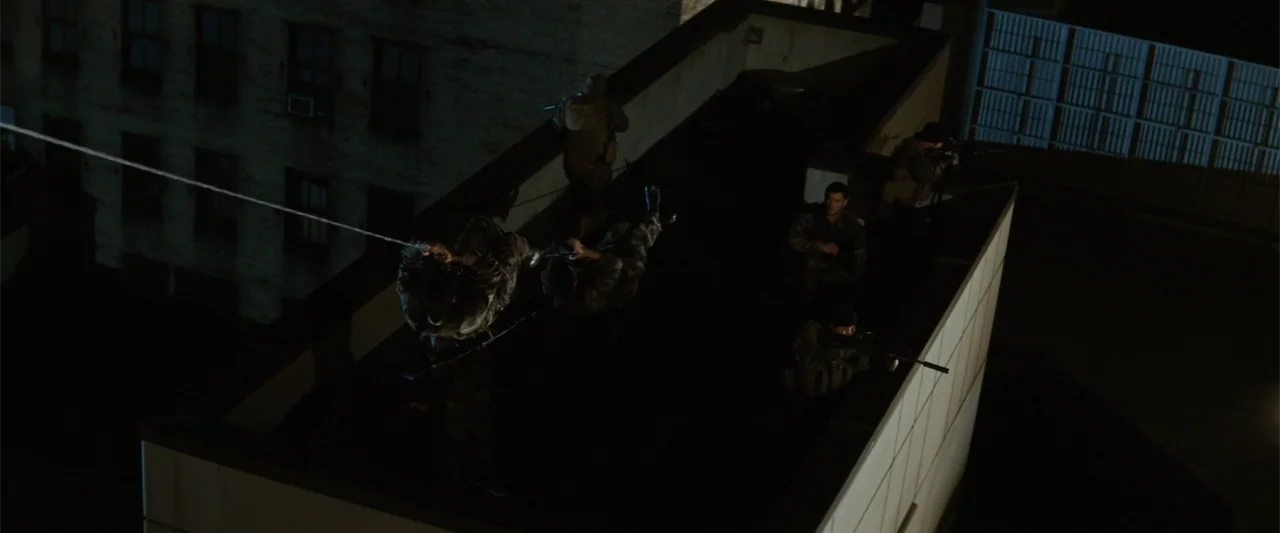 Red Dawn (2012) movie still: wide — A dark urban rooftop serves as the platform for a tactical extraction operation. Multiple armed figures in…
