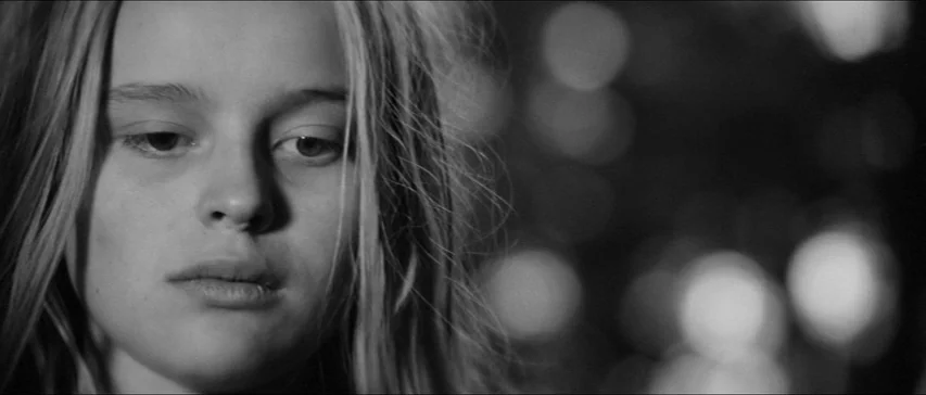Marketa Lazarová (1967) movie still: closeup — A close-up shot focuses on a young woman's face at night. Out of focus street lights create circular…