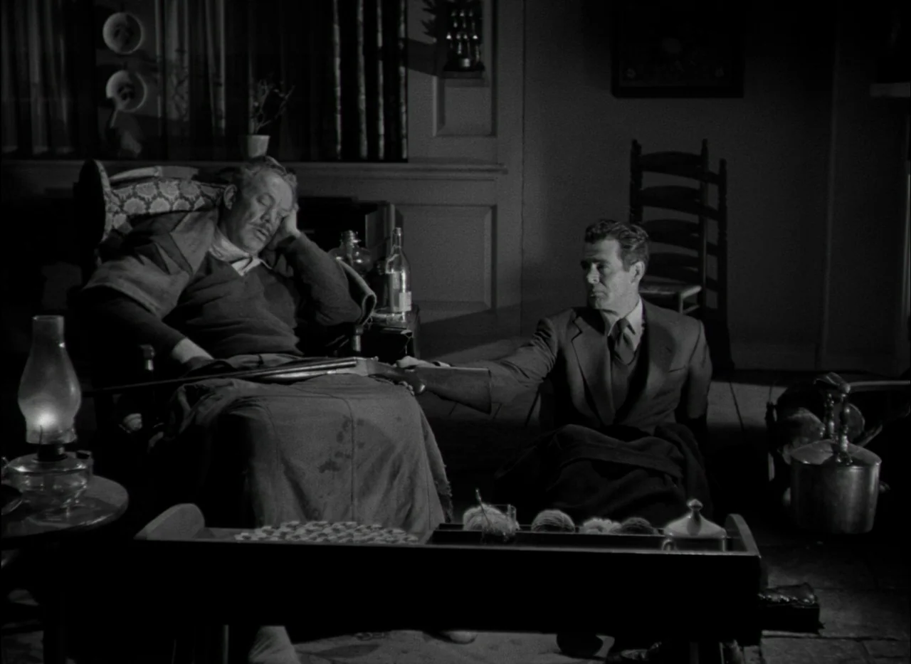 On Dangerous Ground (1951) movie still: medium — A dimly lit room at night features two men near a small table. A man in a suit reaches cautiously…