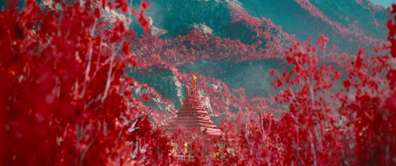 Star Trek Into Darkness (2013) movie still: establishing — A tiered red structure stands in a valley surrounded by dense crimson-leaved trees. The…