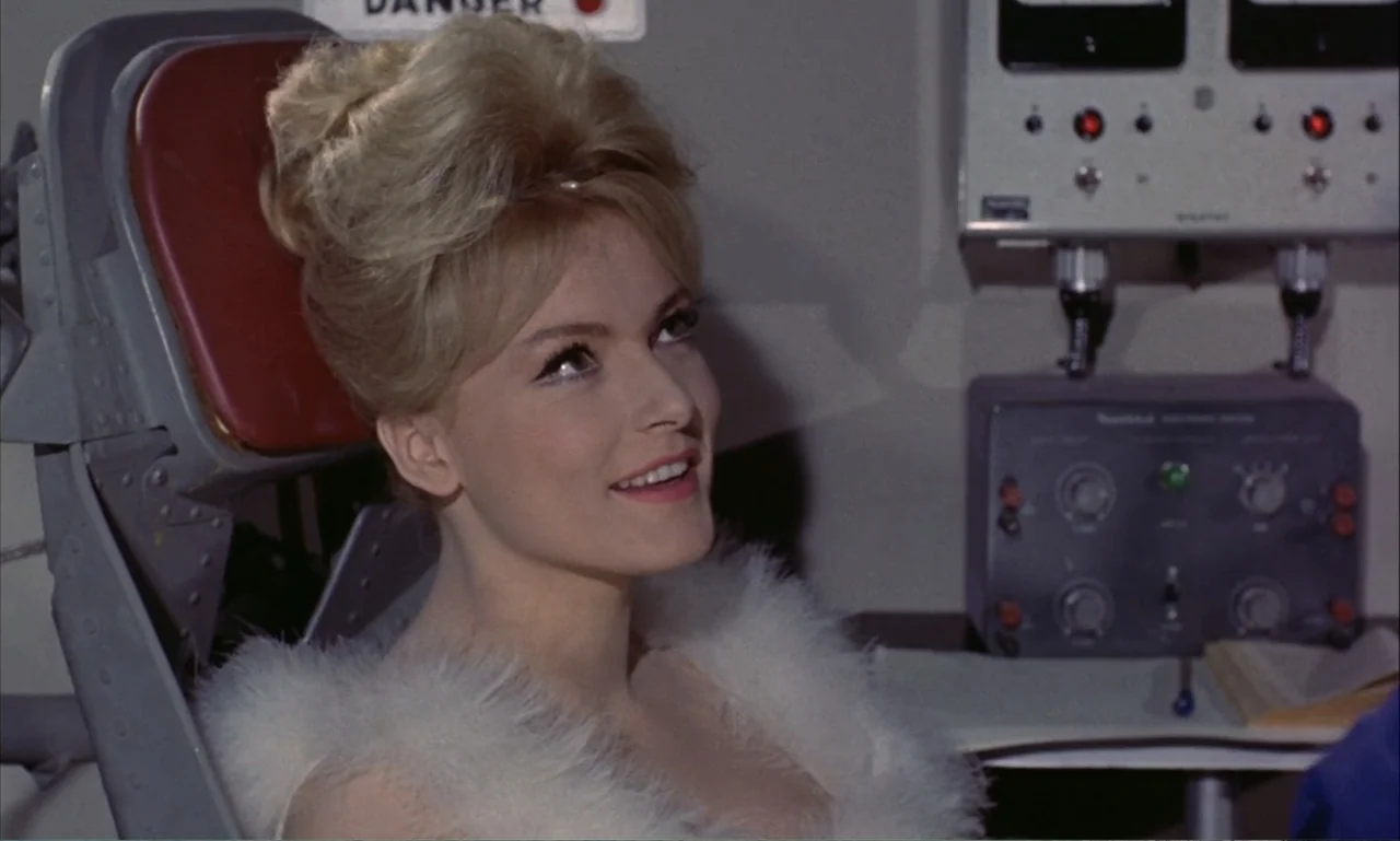 Journey to the Seventh Planet (1962) movie still: closeup — An interior cockpit features mechanical control panels and a pilot seat with red…