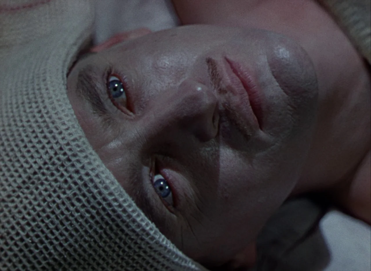 A Matter of Life and Death (1946) movie still: closeup — A close-up view of a person lying on their back in a dimly lit space. The man rests with a…