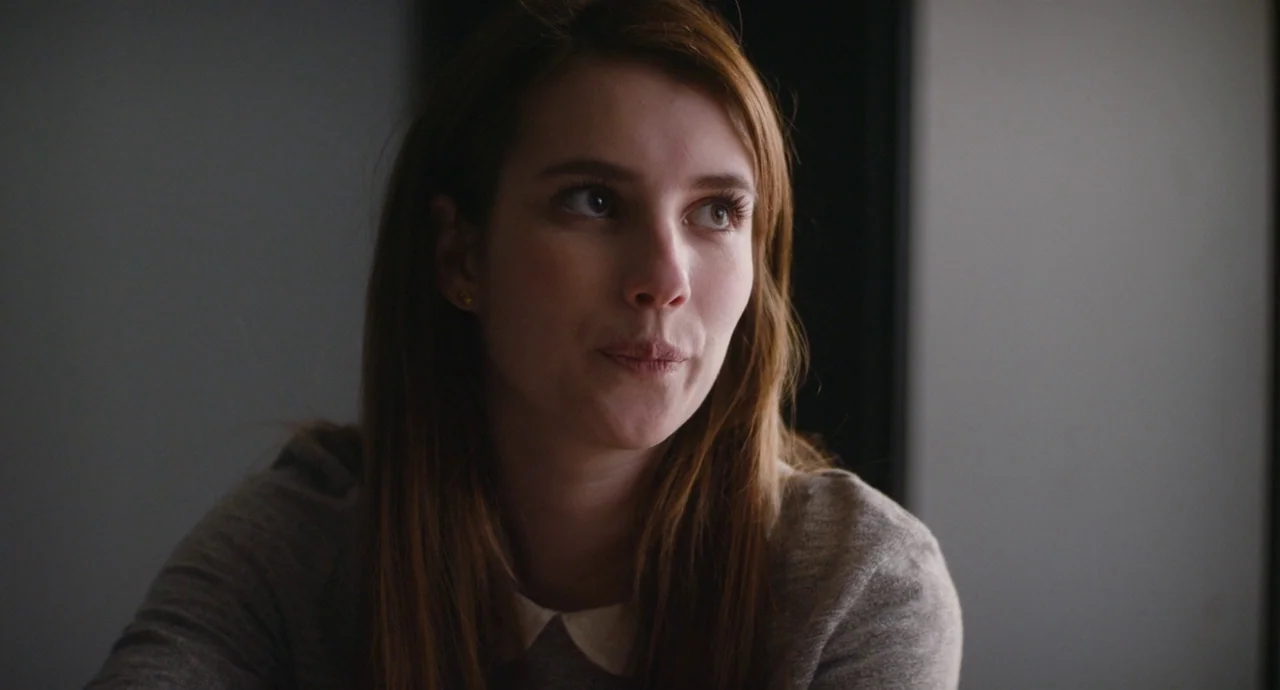 Palo Alto (2013) movie still: closeup — A dimly lit interior space with neutral walls and subtle architectural framing. A young woman with auburn…