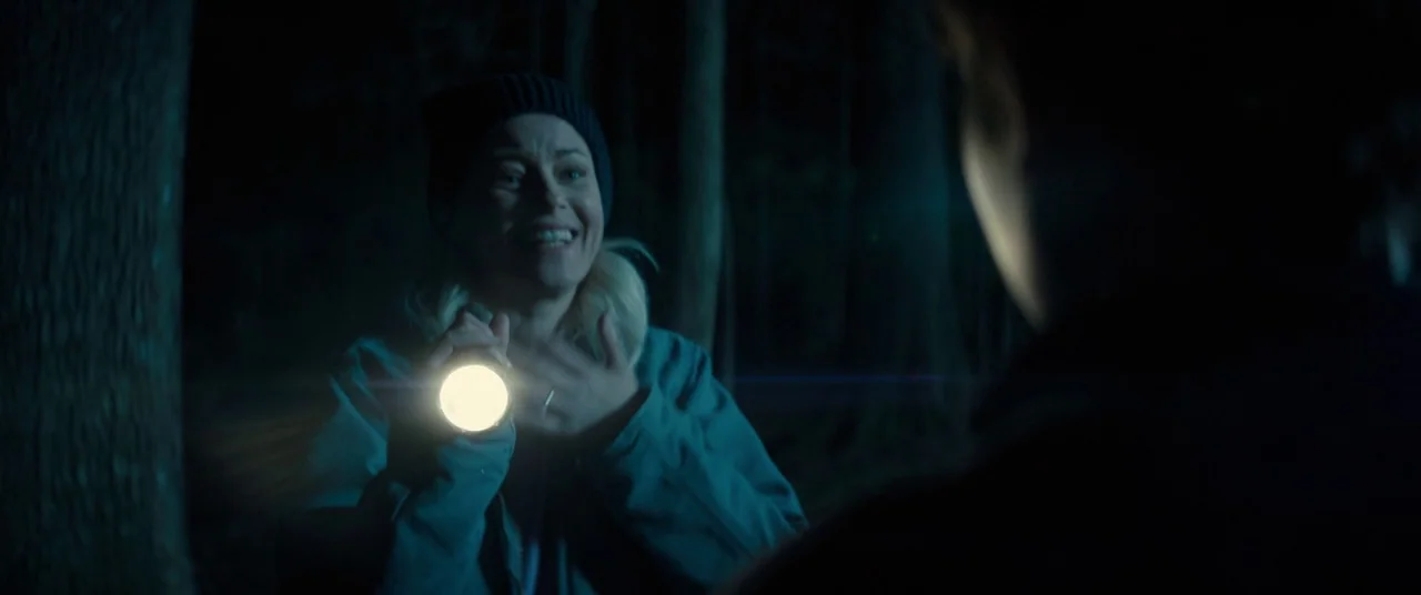 Brightburn (2019) movie still: medium — A dark wooded area at night is illuminated by a single handheld light source. A woman wearing a beanie…