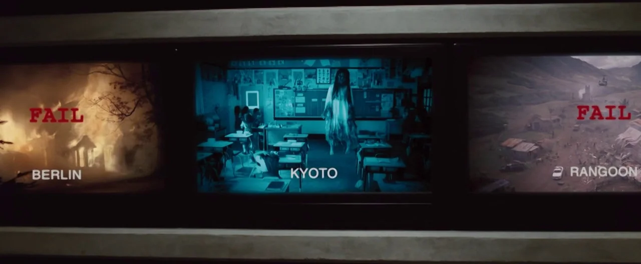 The Cabin In The Woods (2012) movie still: wide — Three monitors mounted on a dark wall display disparate scenes labeled Berlin, Kyoto, and Rangoon.…