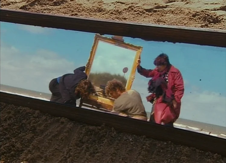 The Beaches of Agnès (2008) movie still: medium — A group of people works on a sandy beach under bright daylight. They arrange a large, ornate…