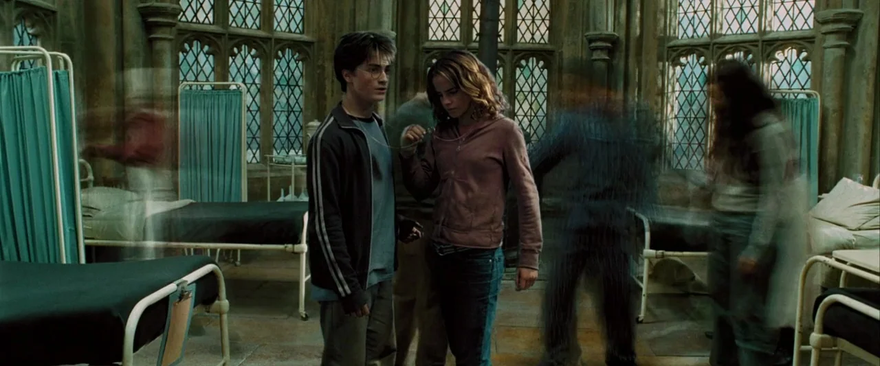 Harry Potter and the Prisoner of Azkaban (2004) movie still: fullbody — A stone infirmary with rows of metal beds and arched windows with leaded…