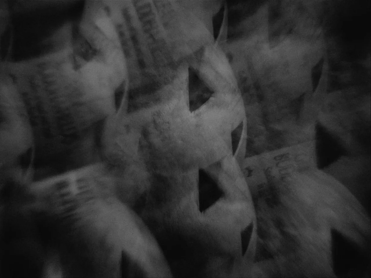 Mala Noche (1986) movie still: closeup — A dark store aisle features repeating rows of blurred, identical bagged products. Each package displays a…