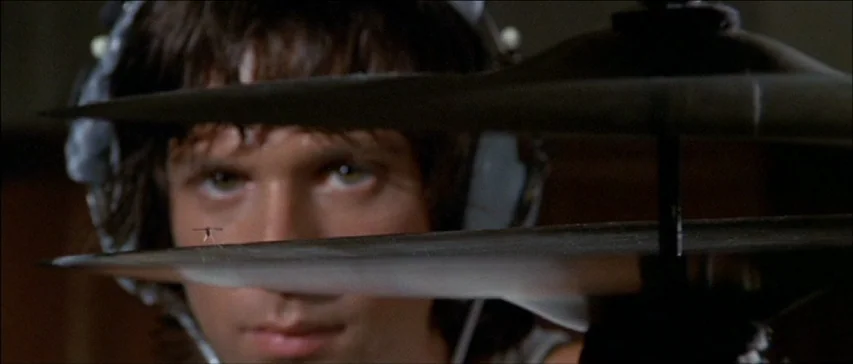 Four Flies On Grey Velvet (1971) movie still: closeup — A dark, dimly lit recording studio with a pair of metallic drum cymbals. A young man wearing…