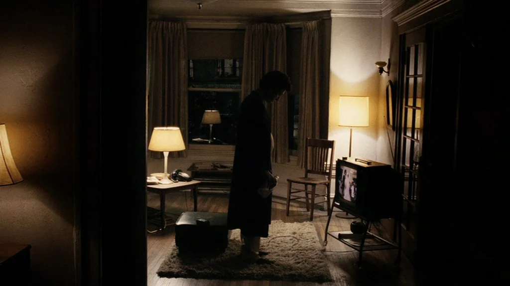 The Assassination of Richard Nixon (2004) movie still: medium — A dimly lit room with vintage furniture and beige curtains framing a window. A man…