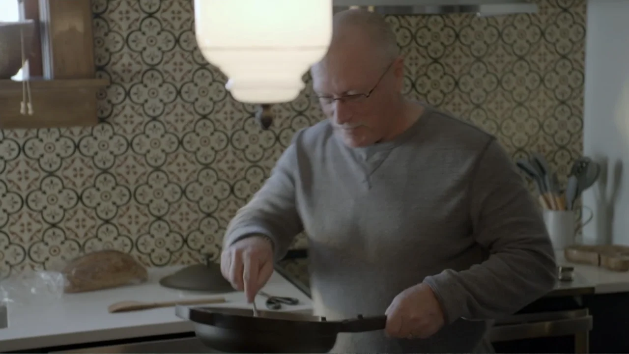 Murders at the Burger Joint (2022) movie still: medium — A residential kitchen features patterned tile backsplashes and modern countertops with…