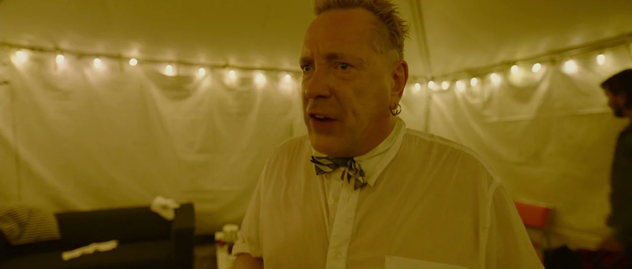 Song to Song (2017) movie still: medium — An interior space enclosed by white fabric walls illuminated by decorative string lights. A man in a…