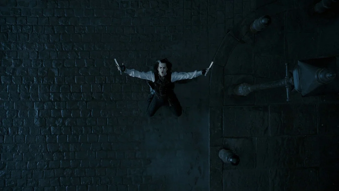 Sweeney Todd: The Demon Barber of Fleet Street (2007) movie still: wide — A dark, wet cobblestone street at night is viewed from a high angle. A man…