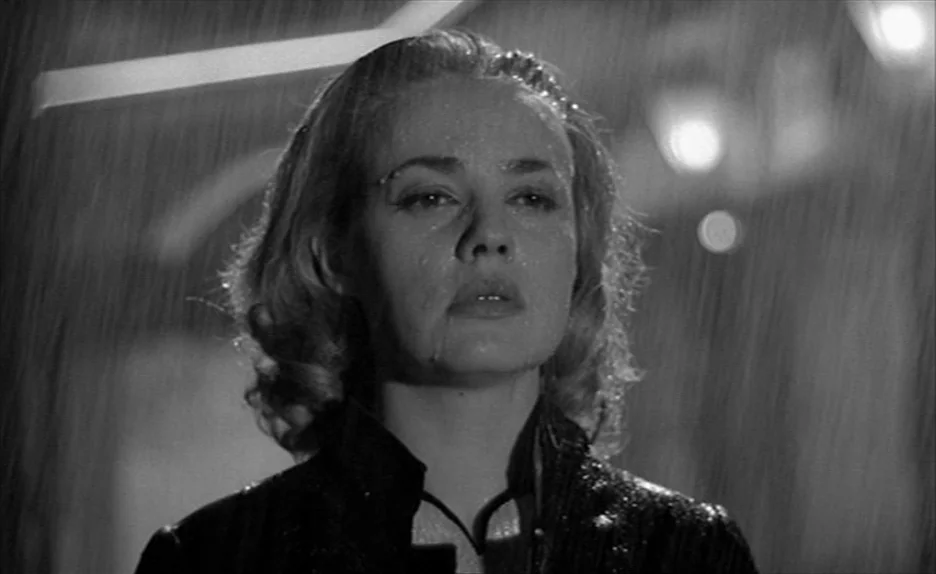 Elevator To The Gallows (Ascenseur pour l’échafaud) (1958) movie still: closeup — A dark, rainy outdoor setting at night with blurred light bokeh in…