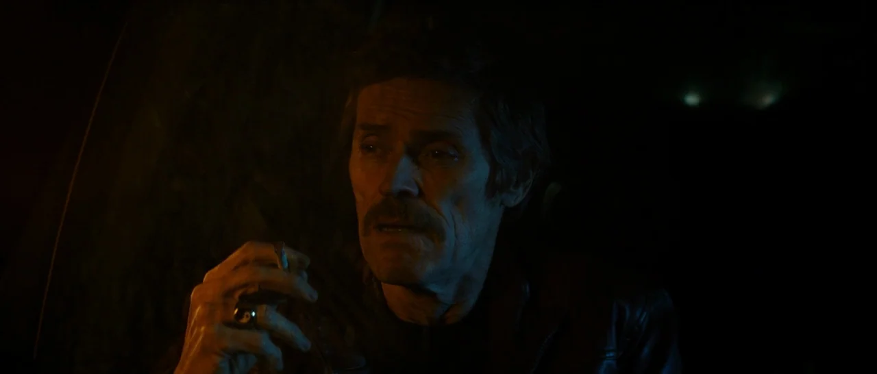 Dog Eat Dog (2016) movie still: closeup — The dark interior of a vehicle at night is illuminated by a subtle light source. A man with a mustache…