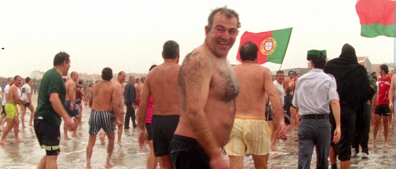 Arabian Nights: Volume 1 – The Restless One (2015) movie still: fullbody — A crowded beach scene during a public event with people walking in…