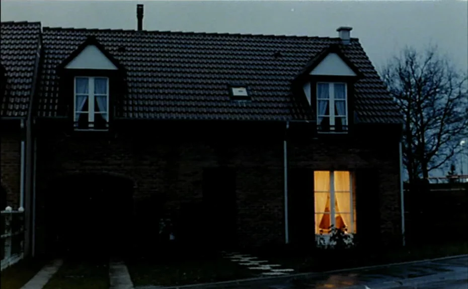 My American Uncle (Mon oncle d’Amérique) (1980) movie still: establishing — A two-story suburban brick house stands in darkness under a muted gray…