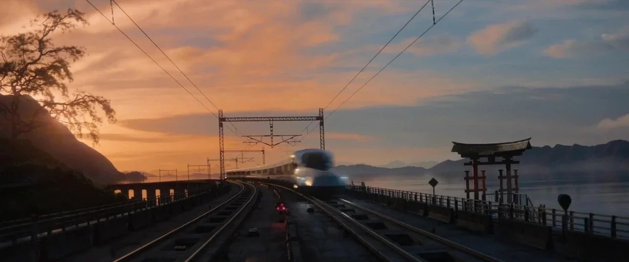 Bullet Train (2022) movie still: wide — A high-speed train moves across a long metal bridge spanning a calm body of water. A traditional Japanese…