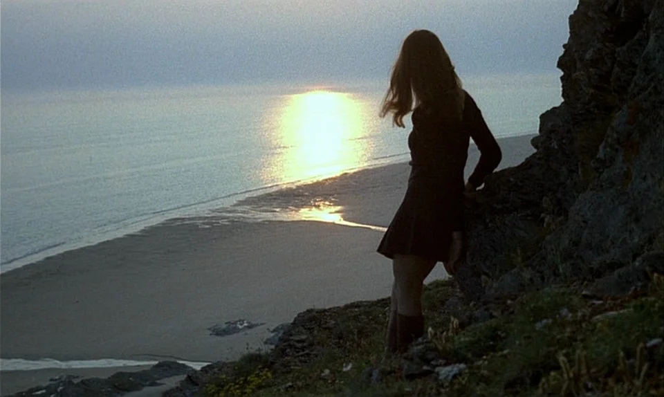 Successive Slidings of Pleasure (Glissements progressifs du plaisir) (1974) movie still: fullbody — A rocky coastal cliff overlooks a calm sea at…