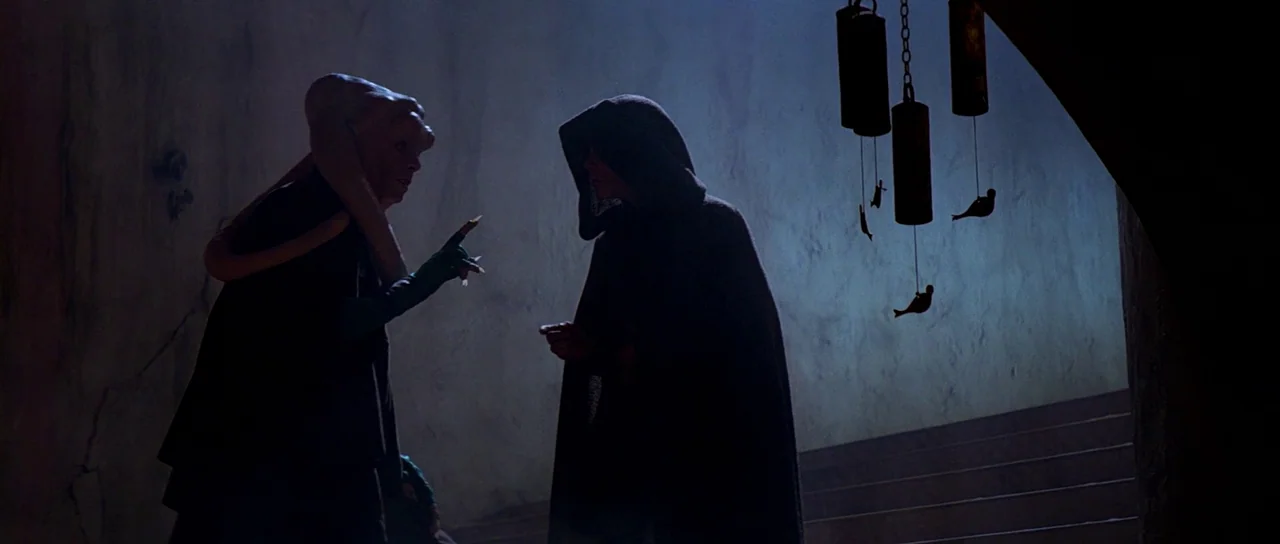 Return Of The Jedi (1983) movie still: fullbody — A stone-walled interior space features hanging metal chimes suspended from an arched ceiling. A…