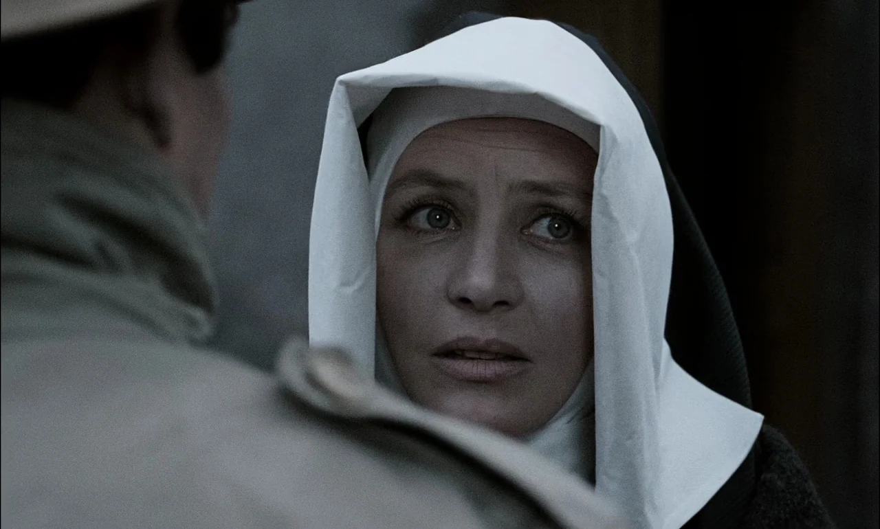The Third Part of the Night (1971) movie still: closeup — A nun stands on a grey city street, framed over the shoulder of another person. She faces…