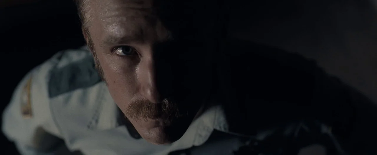 Ain’t Them Bodies Saints (2013) movie still: closeup — A dark, dimly lit environment where a figure is illuminated from a high angle. A man in a…