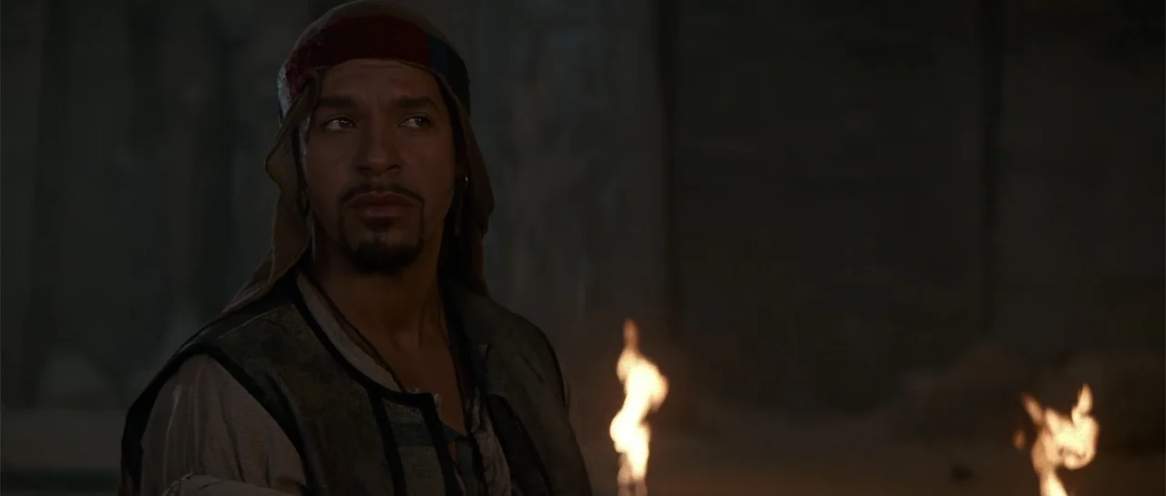 The Mummy Returns (2001) movie still: medium — A dimly lit stone environment with flickering flames visible in the foreground area. A man wears…