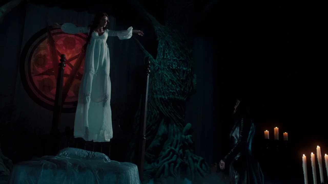 Fright Night (2011) movie still: wide — A dark chamber features a large bed, a gnarled tree-like sculpture, and a glowing red pentagram-style wall…