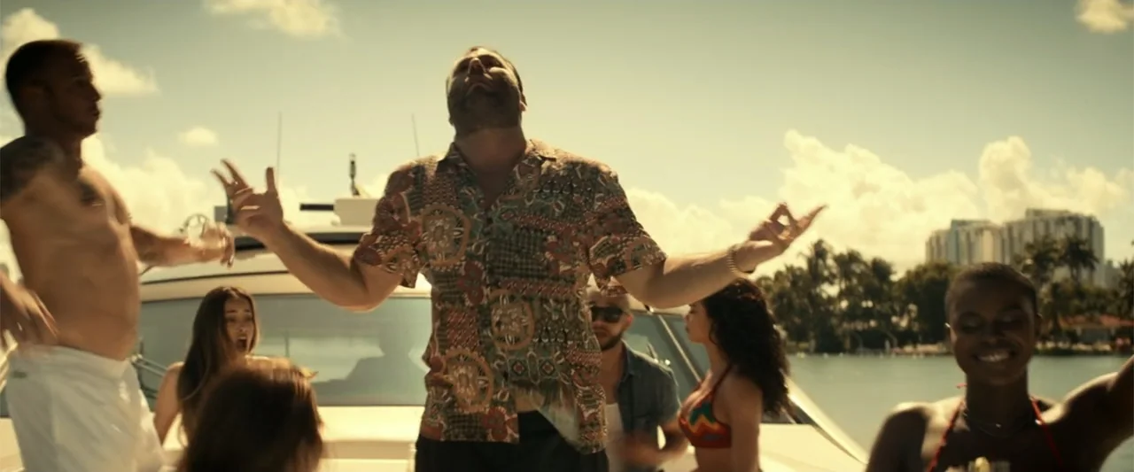Bad Boys for Life (2020) movie still: medium — A crowded deck of a white yacht under a bright blue sky with clouds. A man stands in the foreground…