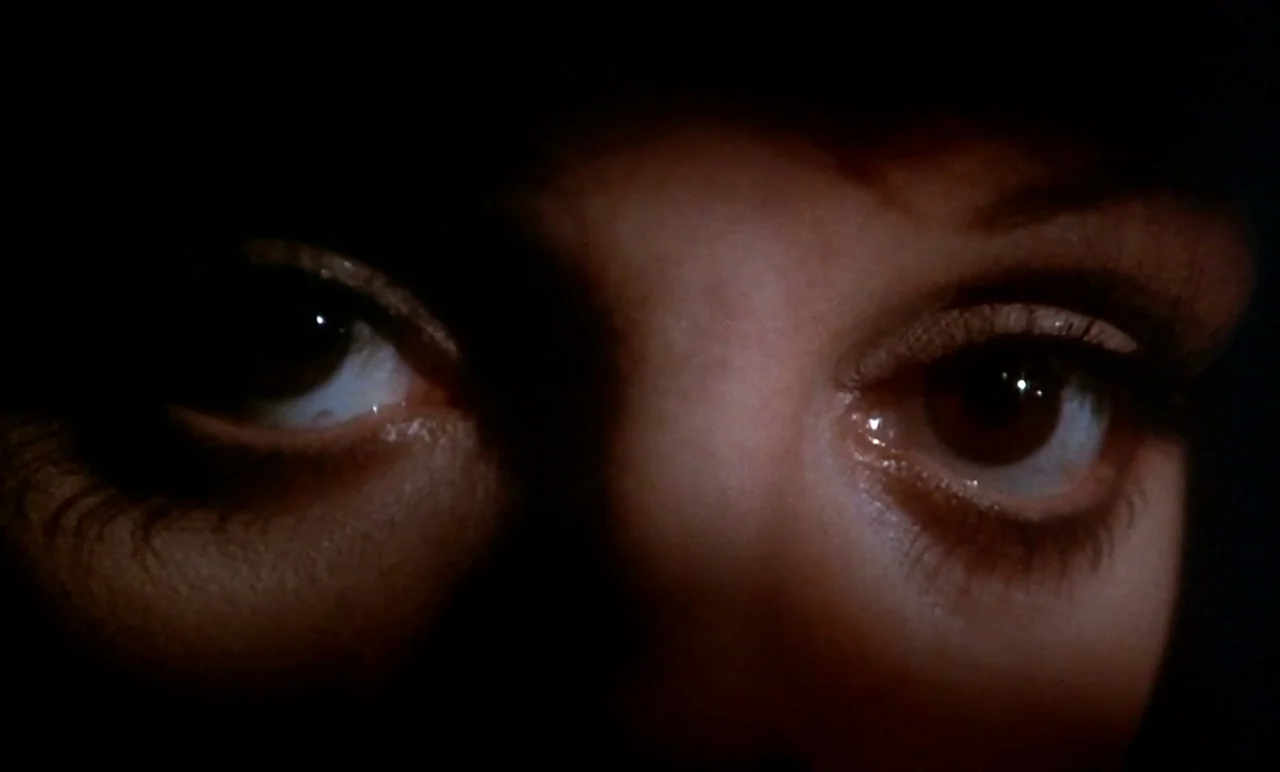 New York, New York (1977) movie still: closeup — A dark space obscures the subject's face except for their eyes. A close-up shot focuses on the…