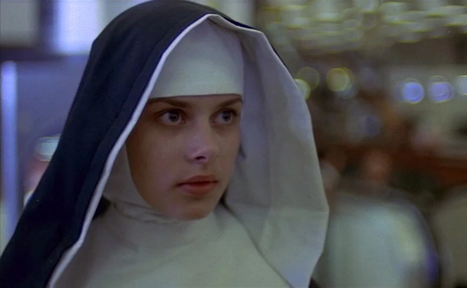 To The Devil a Daughter (1976) movie still: closeup — A close-up shot of a young woman wearing a traditional nun habit. She looks forward while…