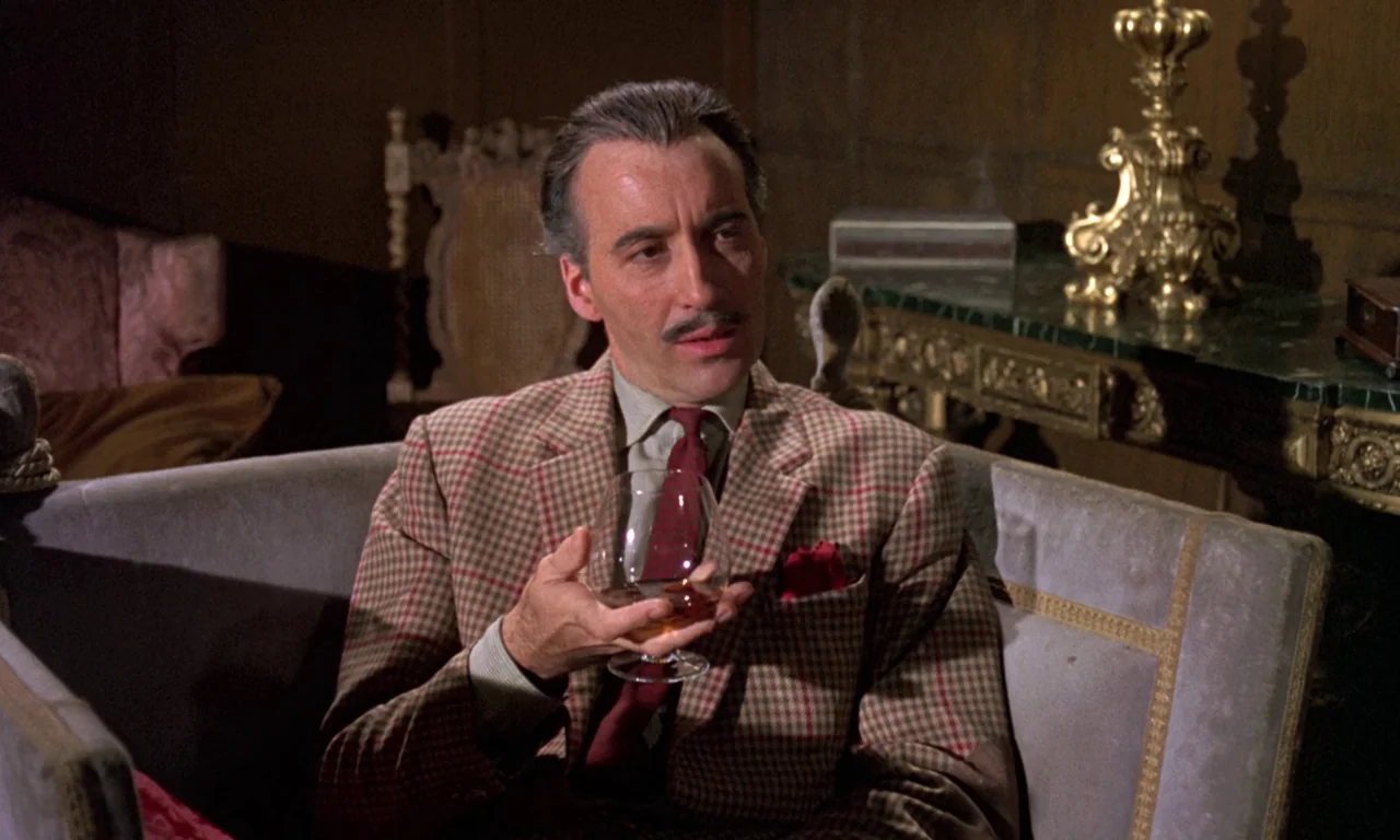 Curse of the Crimson Altar (1968) movie still: medium — An opulent interior with wood paneled walls, ornate gilded furniture, and heavy velvet…