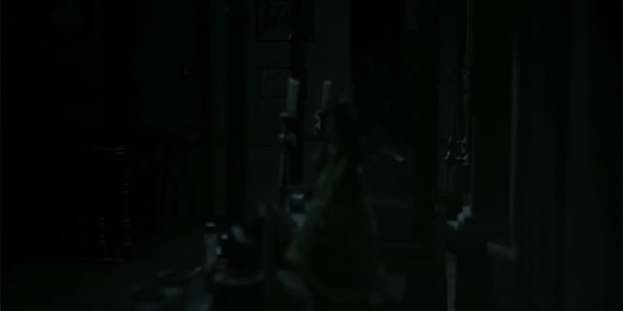 Nokturno (2024) movie still: wide — A dark, dimly lit room contains a dining table with two standing candlesticks. The background is obscured by…
