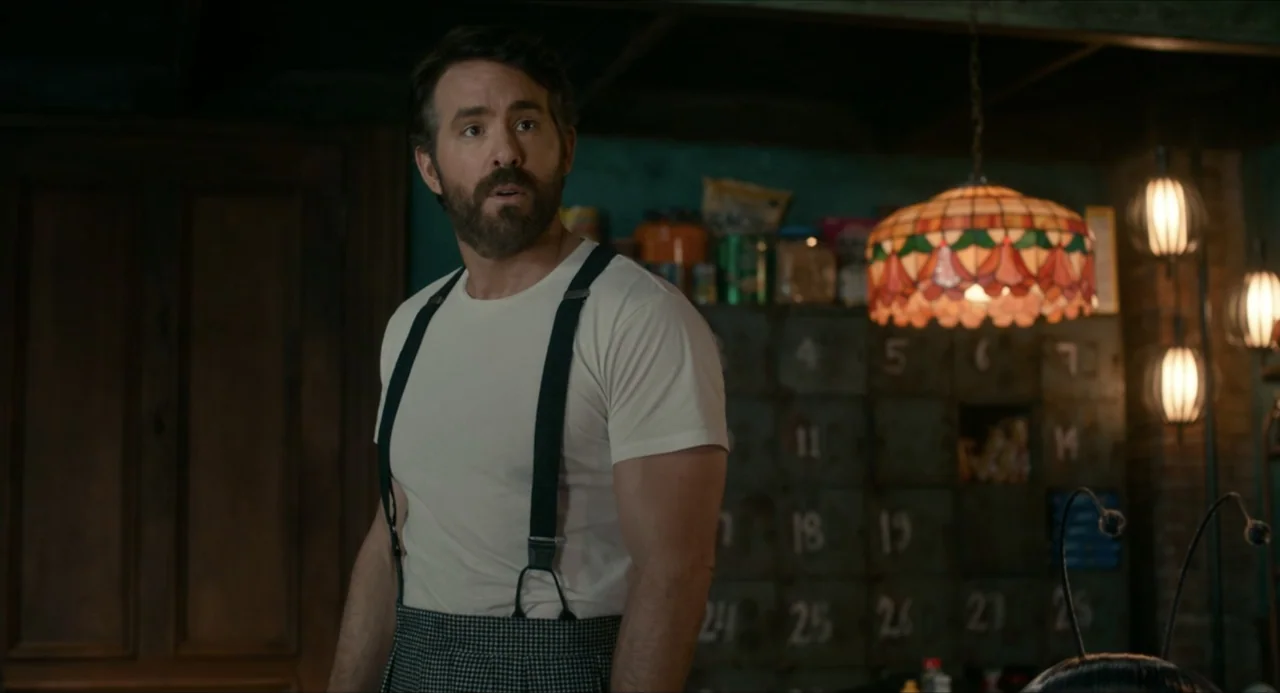 IF (2024) movie still: medium — A dimly lit basement features a wall of numbered storage lockers and dark wood paneling. A man in a t-shirt and…