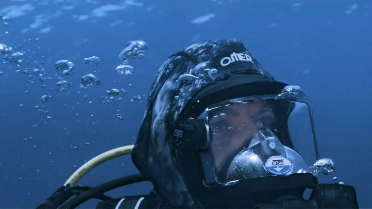 Serial Killer: Red Sea Attacks (2023) movie still: closeup — An underwater setting with blue water illuminated by ambient light from the surface. A…
