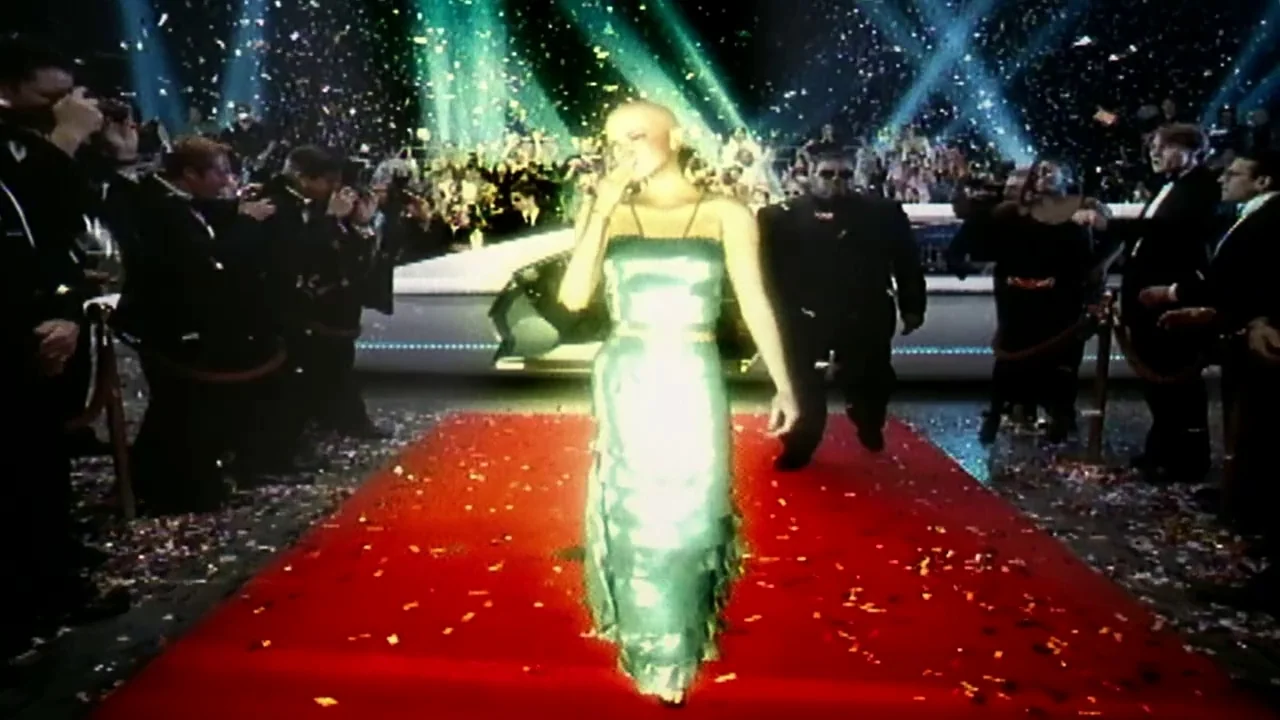 Naqoyquatsi (2002) movie still: fullbody — A woman walks down a red carpet surrounded by photographers in black suits. Confetti lit by bright…
