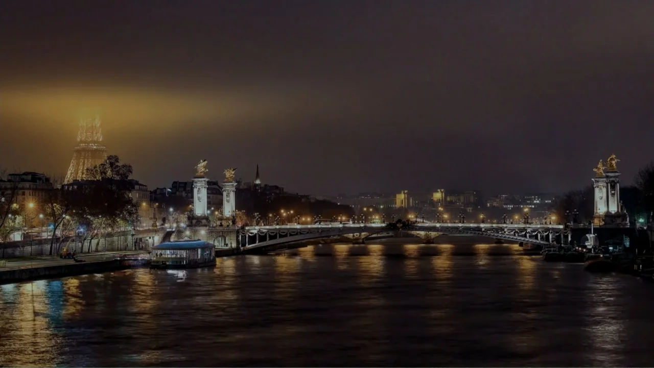 Reign of the Superwomen (2021) movie still: establishing — A night view of the Pont Alexandre III bridge across the Seine in Paris. The bridge is…