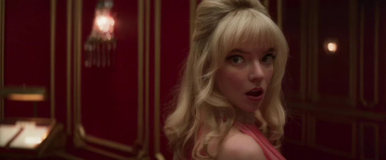 Last Night in Soho (2021) movie still: closeup — A corridor features rich red walls accented with ornate gold molding and sconces. A young blonde…