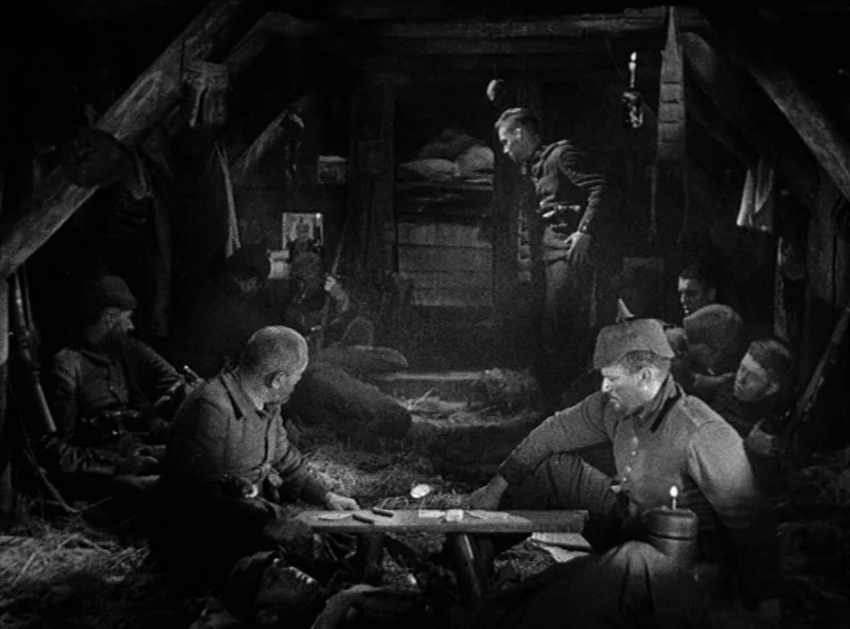 All Quiet on the Western Front (1930) movie still: medium — A dimly lit dirt-walled dugout is reinforced with heavy wooden beams and thatch bedding.…