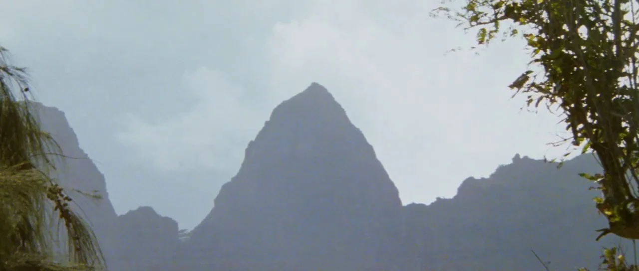 Raiders Of The Lost Ark (1981) movie still: establishing — A series of pointed volcanic mountain peaks stand against a pale, overcast sky. Foliage…