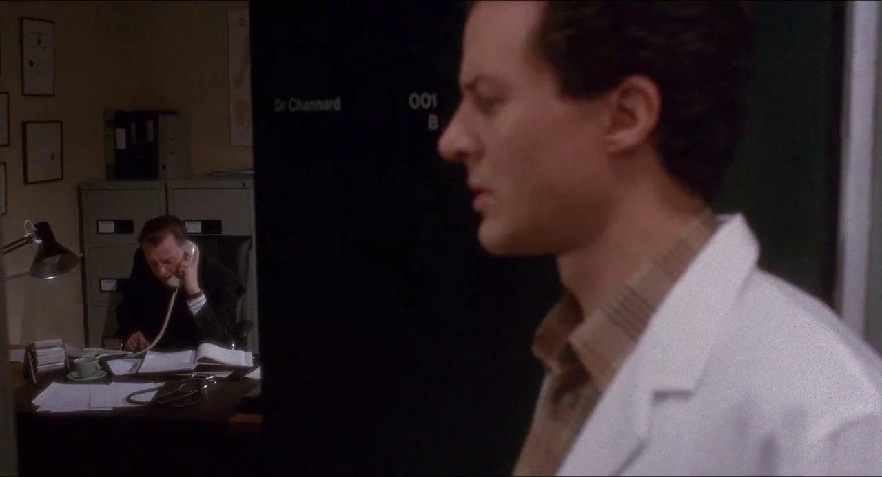 Hellbound: Hellraiser II (1988) movie still: medium — An office features gray metal filing cabinets and a desk covered in papers and records. A…