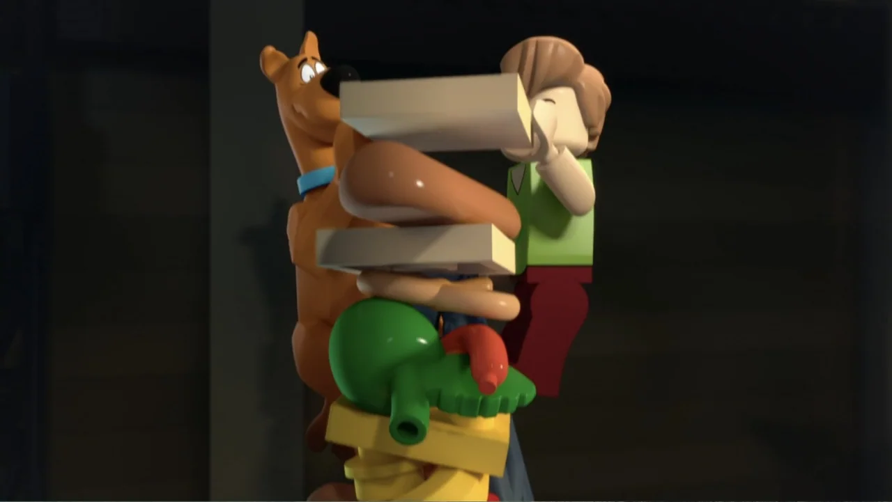 LEGO Scooby-Doo! Haunted Hollywood (2016) movie still: medium — A dark indoor space serves as the background for two stylized plastic figures. A man…