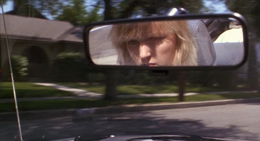 A Nightmare On Elm Street 4: The Dream Master (1988) movie still: closeup — A view through a rearview mirror showing a person driving through a…