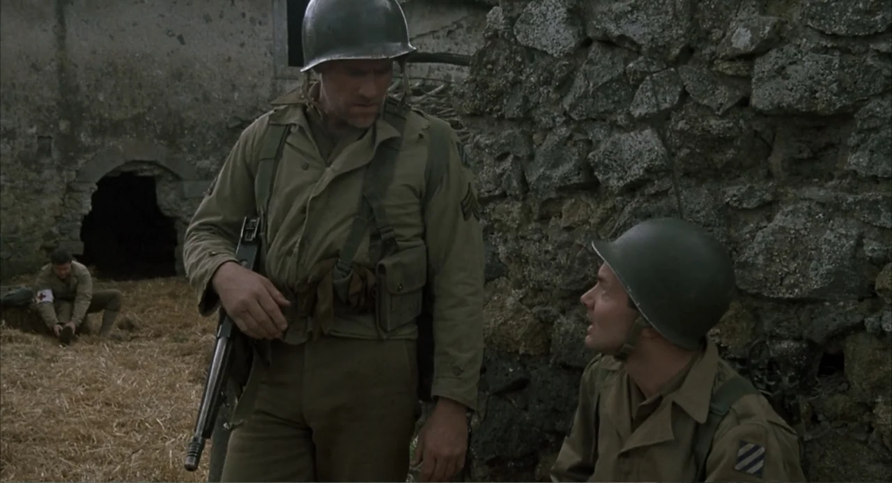 Zone Troopers (1985) movie still: medium — A war-torn stone structure provides a backdrop for three soldiers in 1940s military attire. Two soldiers…