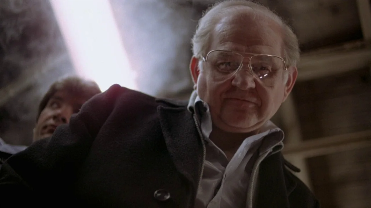 Thief (1981) movie still: medium — An industrial-looking interior space with dim surroundings and overhead fluorescent lighting. An older man…