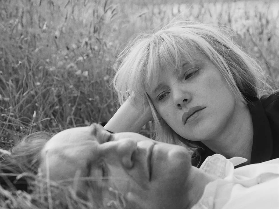 Cold War (2018) movie still: closeup — Two individuals lie together in a grassy field on an overcast day. A woman looks down at the man lying beside…