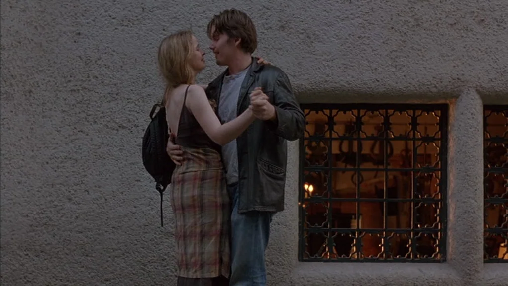 Before Sunrise (1995) movie still: fullbody — A couple stands against a rough-textured stone wall at night near a window. The man holds the woman's…