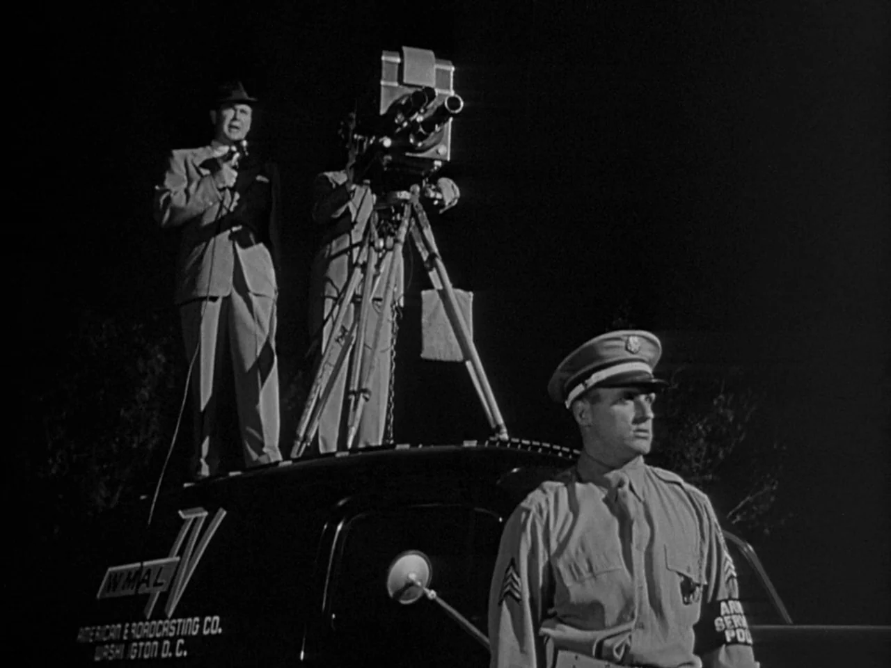 The Day the Earth Stood Still (1951) movie still: fullbody — A television broadcast van is parked at night with a cameraman and reporter atop. A…