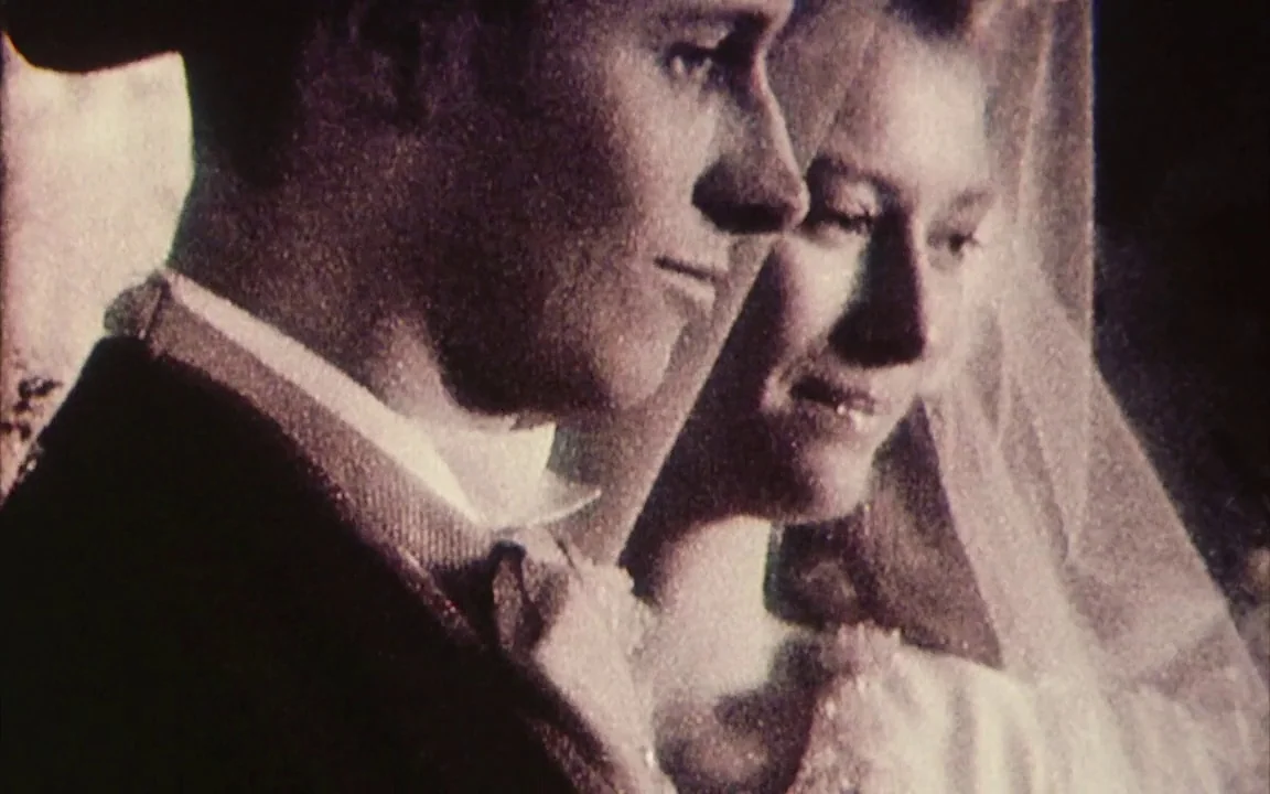 The Last of England (1987) movie still: closeup — A close-up shot of a young bride and groom during a 1950s wedding. The couple stands together…